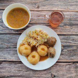 Zdjęcie przedstawia Dietę podstawową: Zupa ziemniaczana a'la solferino Kluski śląskie Klopsik wieprzowy pieczony Sos pieczeniowy Surówka z kapusty pekińskiej z olejem Kompot owocowy z jabłkami